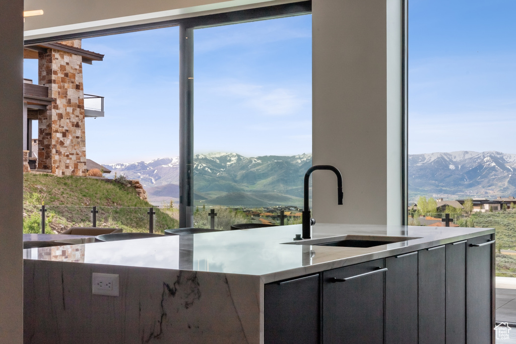 Kitchen with a mountain view, a sink, modern cabinets, and light countertops