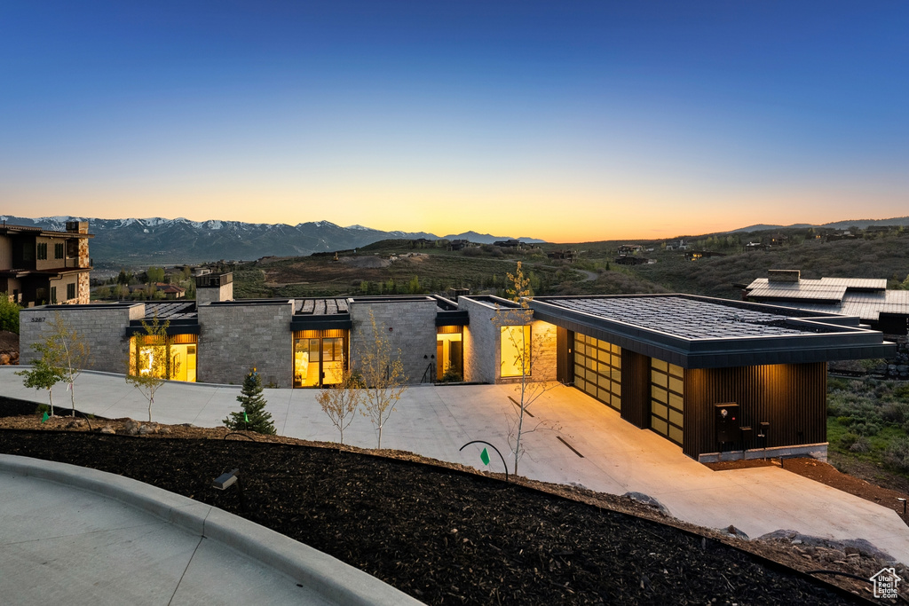 View of front of home with a mountain view and a garage