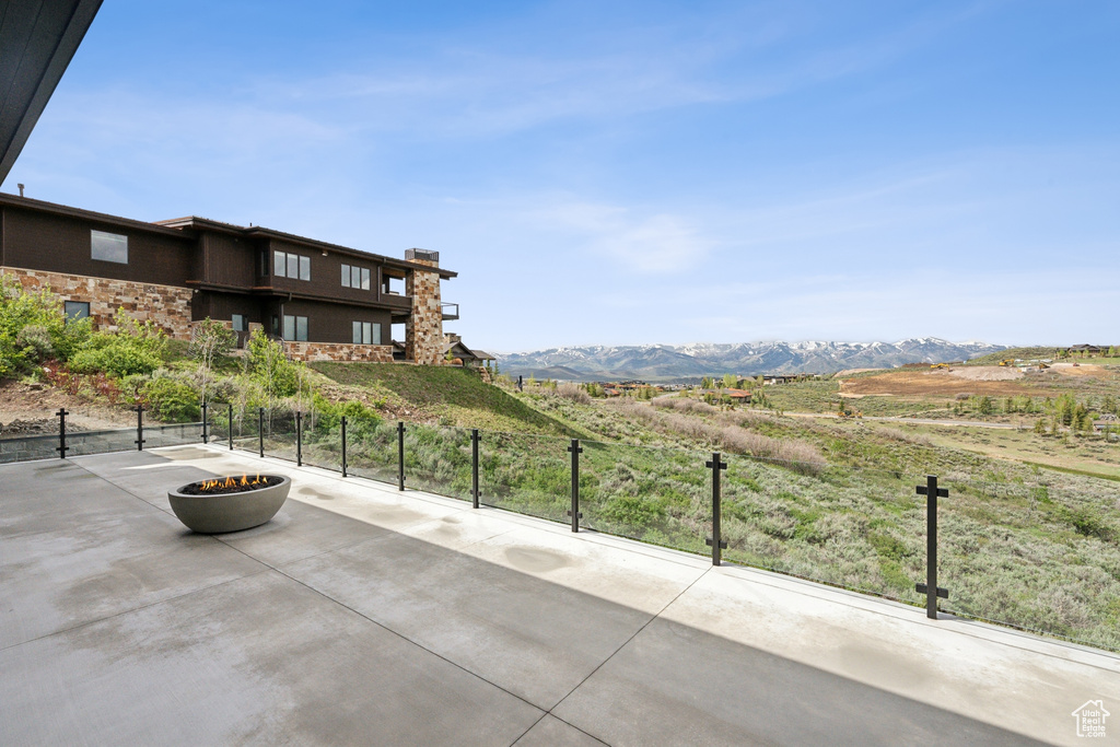 View of patio featuring an outdoor fire pit, a mountain view, and a view of rural / pastoral area