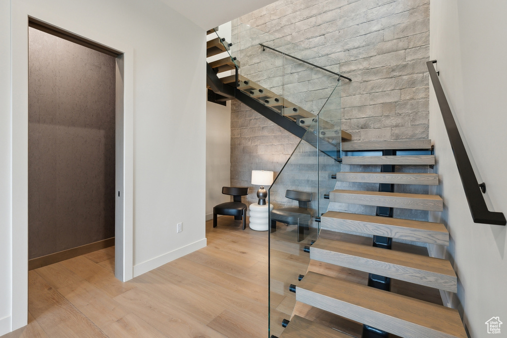 Stairway with wood finished floors and baseboards