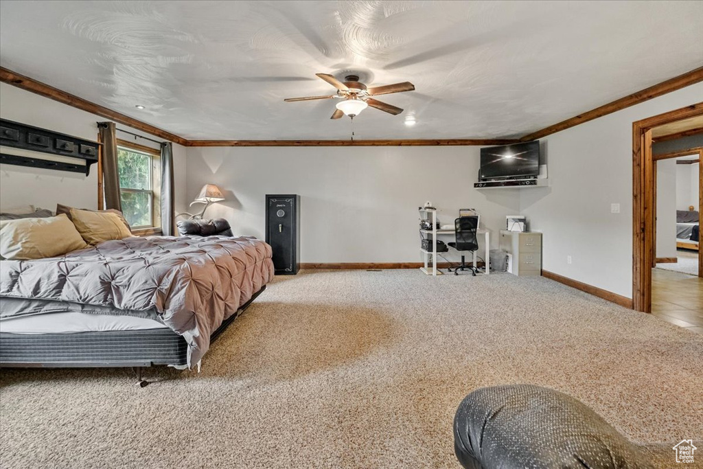 Bedroom with light carpet, ceiling fan, and crown molding