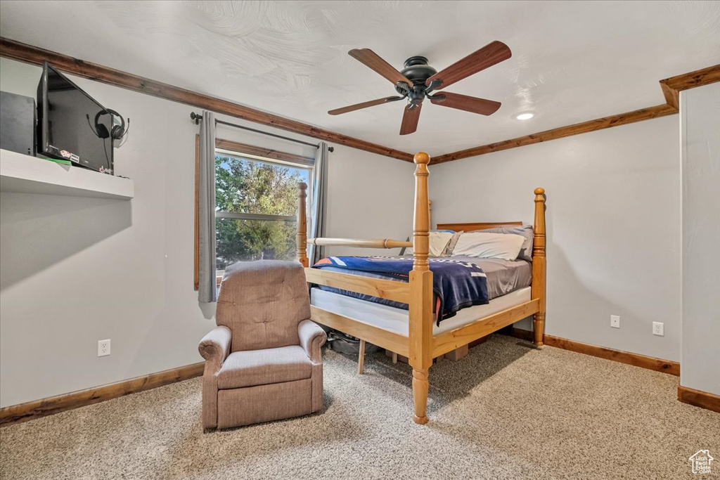Bedroom with carpet floors, ceiling fan, and crown molding