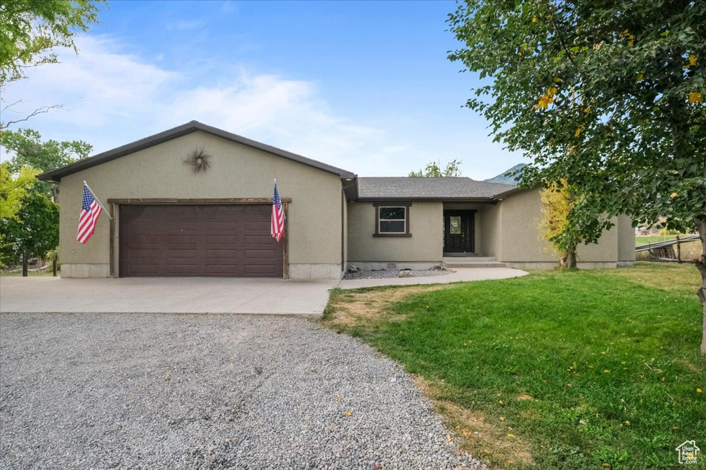 Ranch-style house with a front lawn and a garage