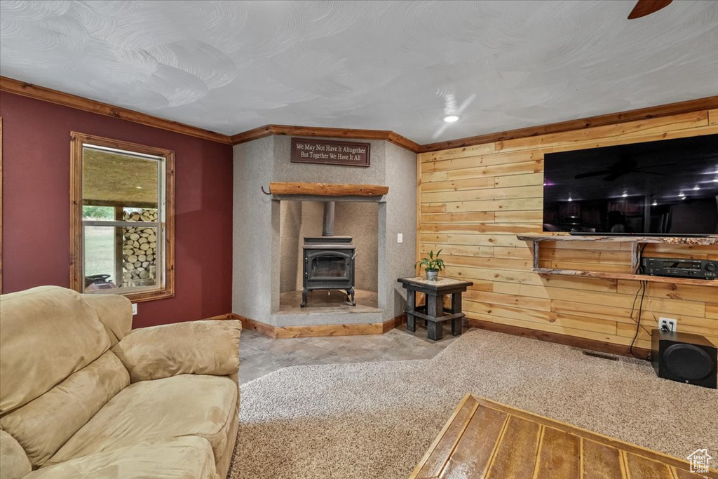 Living room with a wood stove, ornamental molding, and light carpet