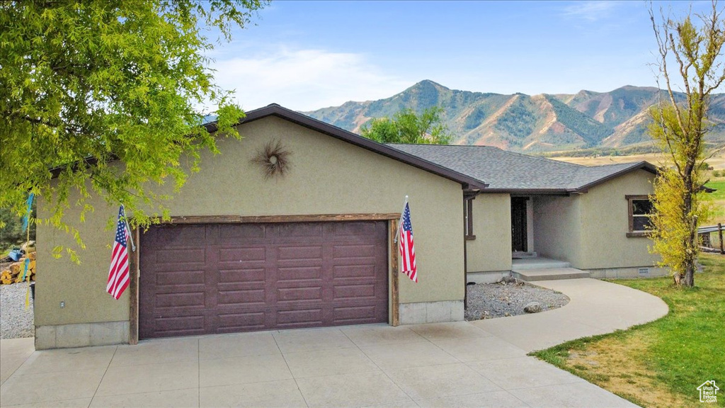 Single story home with a mountain view and a garage