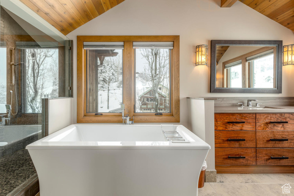 Full bath with vaulted ceiling, wood ceiling, a soaking tub, and vanity