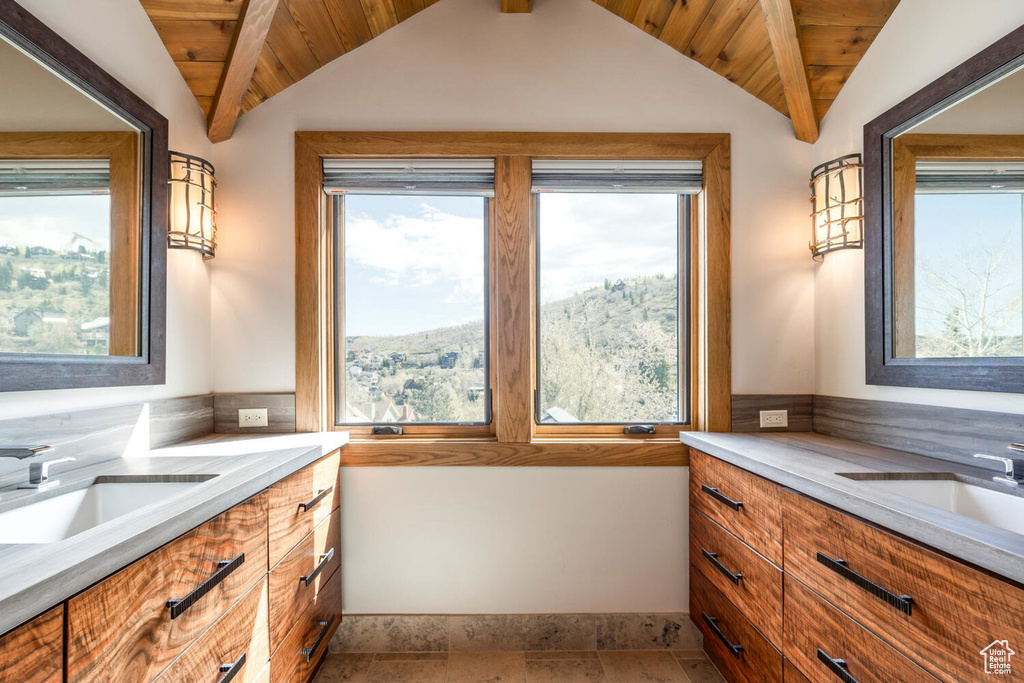 Bathroom featuring vanity, vaulted ceiling, healthy amount of natural light, and wood ceiling