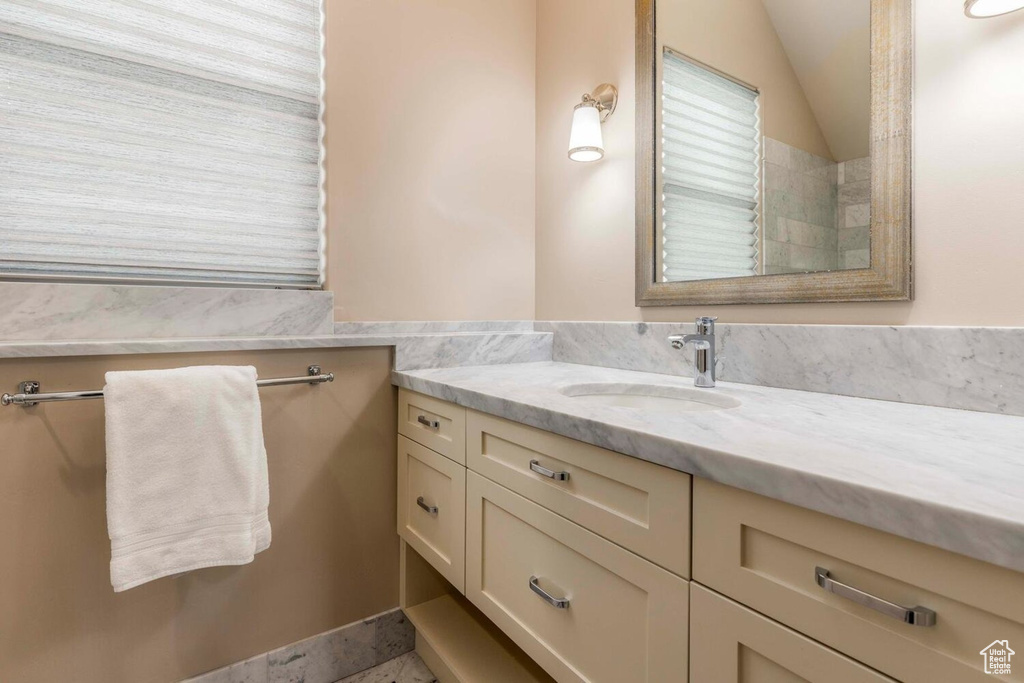 Full bath with vanity and lofted ceiling
