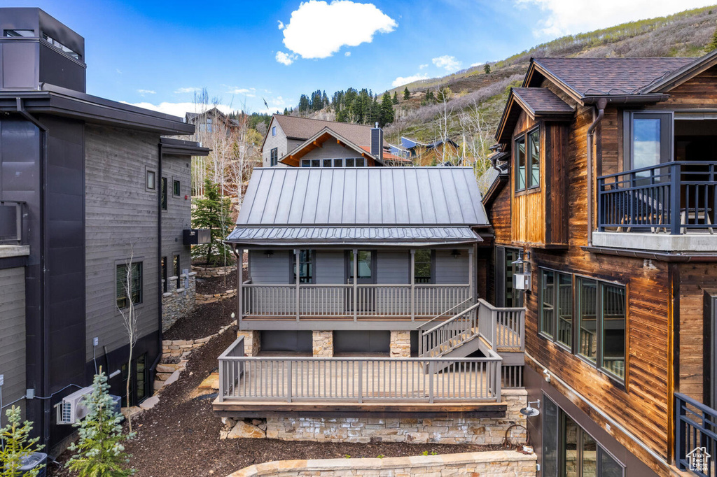 Back of property with a mountain view, metal roof, and a standing seam roof