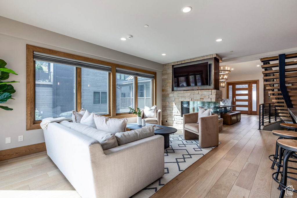 Living area featuring light wood-style flooring, a fireplace, recessed lighting, and baseboards