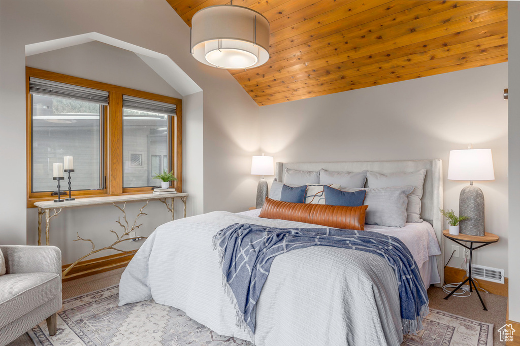 Bedroom with lofted ceiling, wood ceiling, and carpet flooring