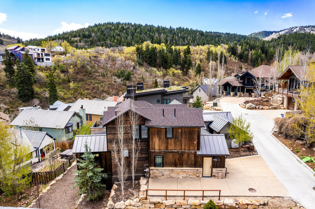 Aerial view of residential area featuring a forest and mountains