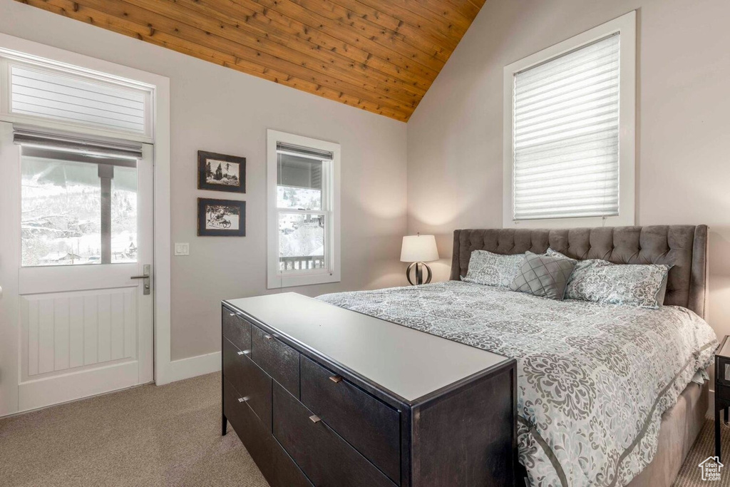 Bedroom featuring lofted ceiling, wood ceiling, light colored carpet, and baseboards