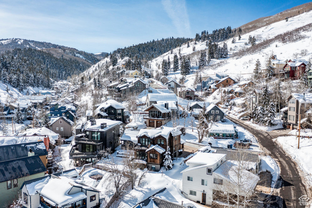 Snowy aerial view featuring a mountain view and a residential view
