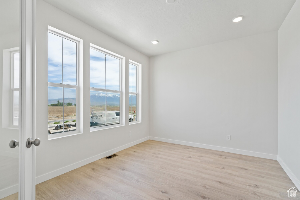 Empty room with light wood-type flooring, baseboards, and recessed lighting