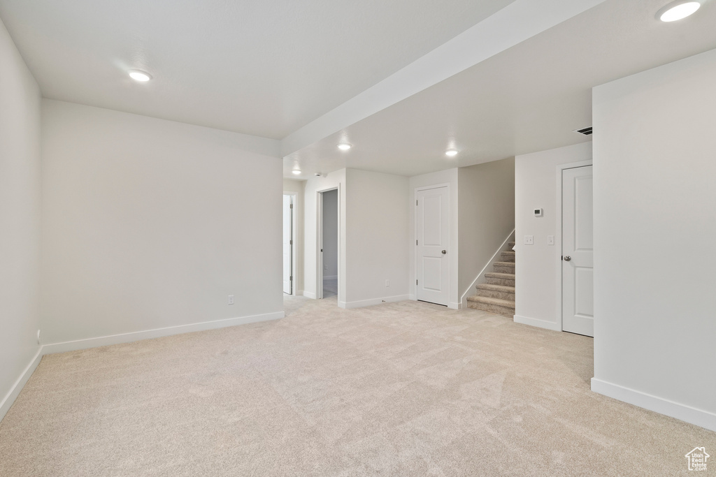 Spare room with recessed lighting, light carpet, baseboards, and stairway