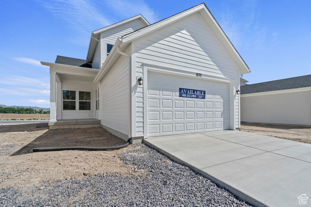 View of side of property with a garage and driveway