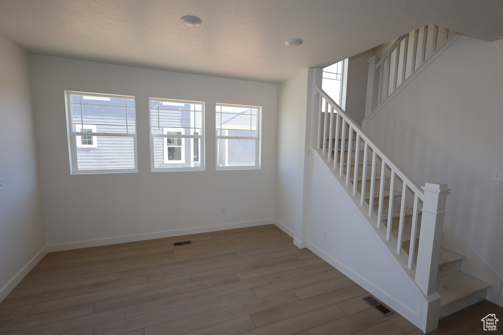 Staircase featuring visible vents, plenty of natural light, and wood finished floors