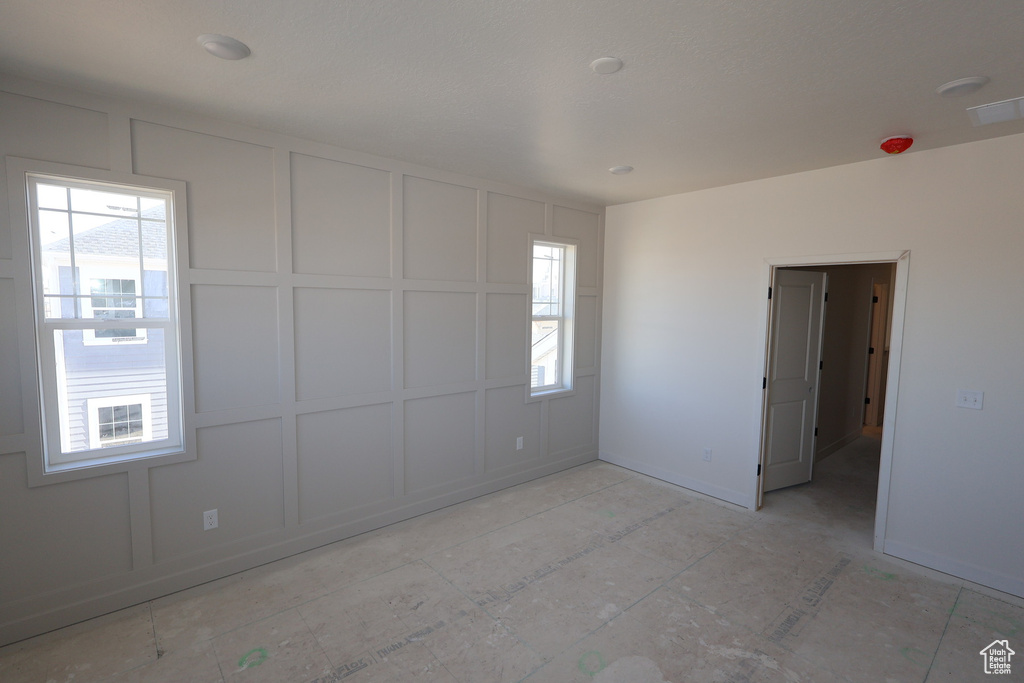 Empty room featuring a decorative wall and visible vents