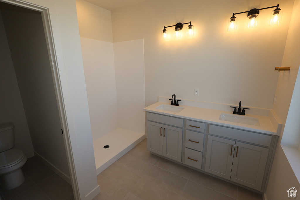 Full bath with tile patterned floors, toilet, a walk in shower, and a sink