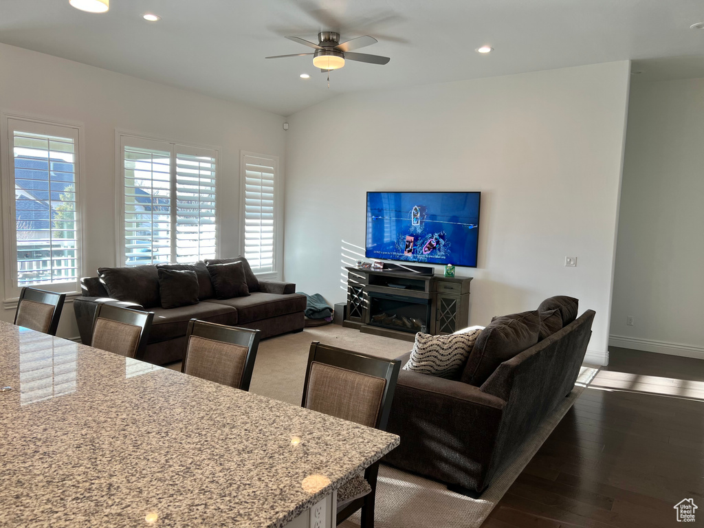 Living room featuring ceiling fan, hardwood / wood-style floors, and lofted ceiling
