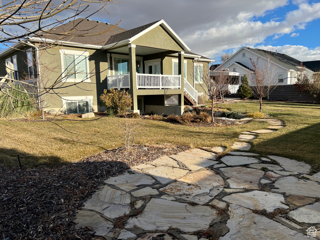 Back of house featuring a porch, central AC unit, and a lawn