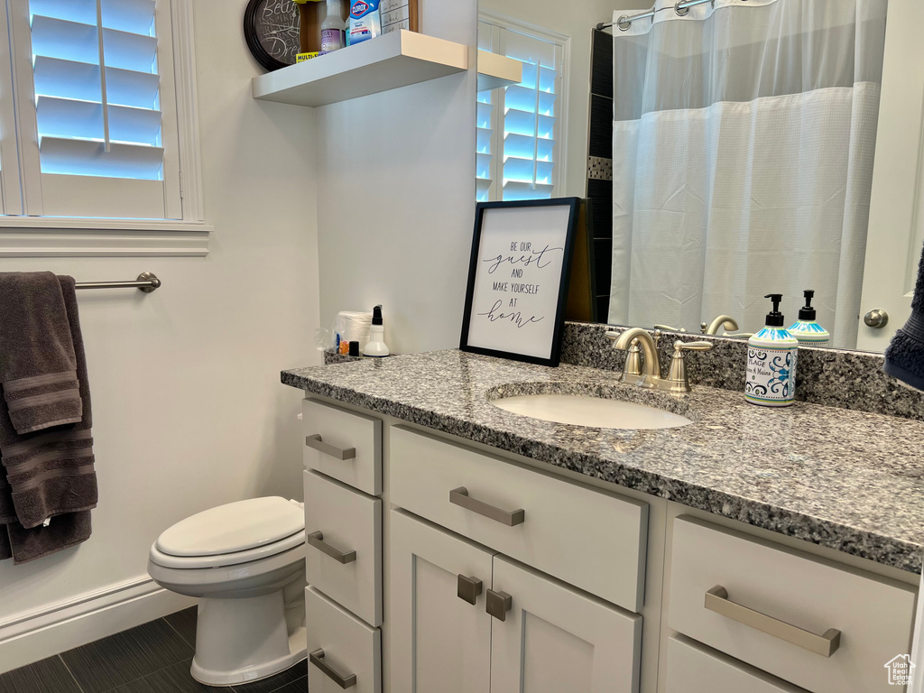 Bathroom featuring tile patterned flooring, vanity, and toilet