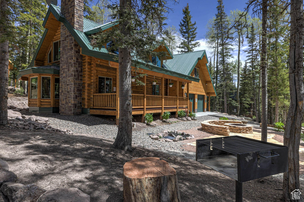 Rear view of house featuring a fire pit and a porch