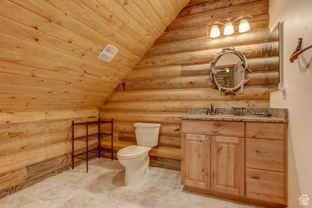 Bathroom with vanity, lofted ceiling, toilet, log walls, and wood ceiling