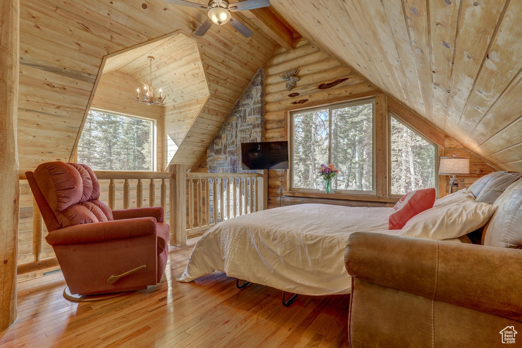 Bedroom with vaulted ceiling with beams, ceiling fan with notable chandelier, wood-type flooring, and wooden ceiling
