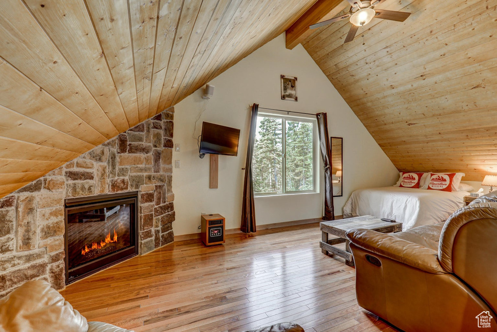Bedroom featuring vaulted ceiling with beams, light wood-type flooring, ceiling fan, and wooden ceiling