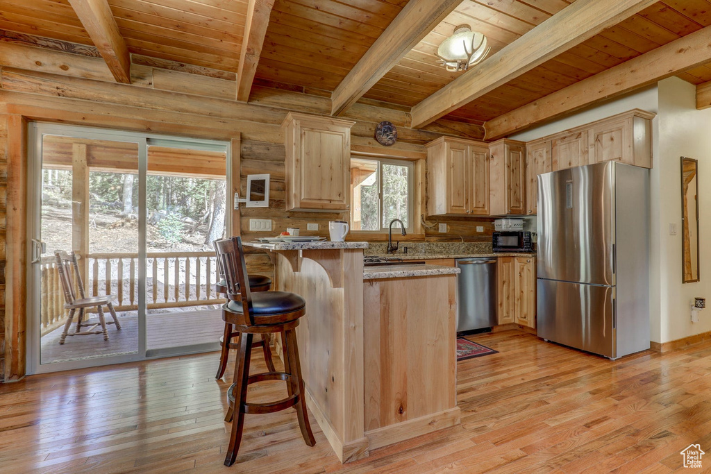 Kitchen featuring appliances with stainless steel finishes, light hardwood / wood-style floors, light brown cabinetry, and wood ceiling