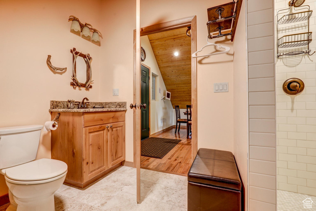 Bathroom with a shower, lofted ceiling, vanity, wood ceiling, and hardwood / wood-style flooring