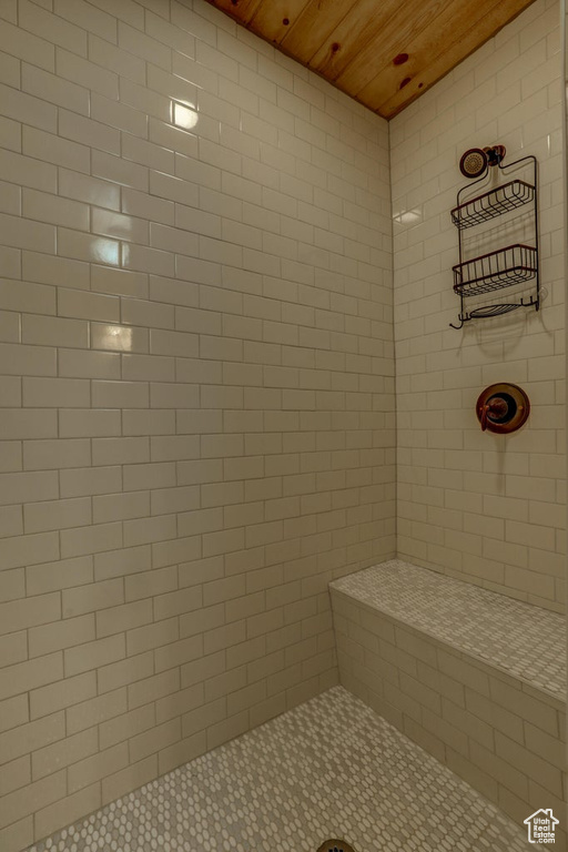 Bathroom featuring wood ceiling and tiled shower