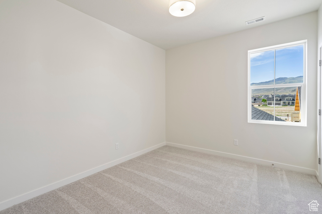 Unfurnished room featuring baseboards and light colored carpet