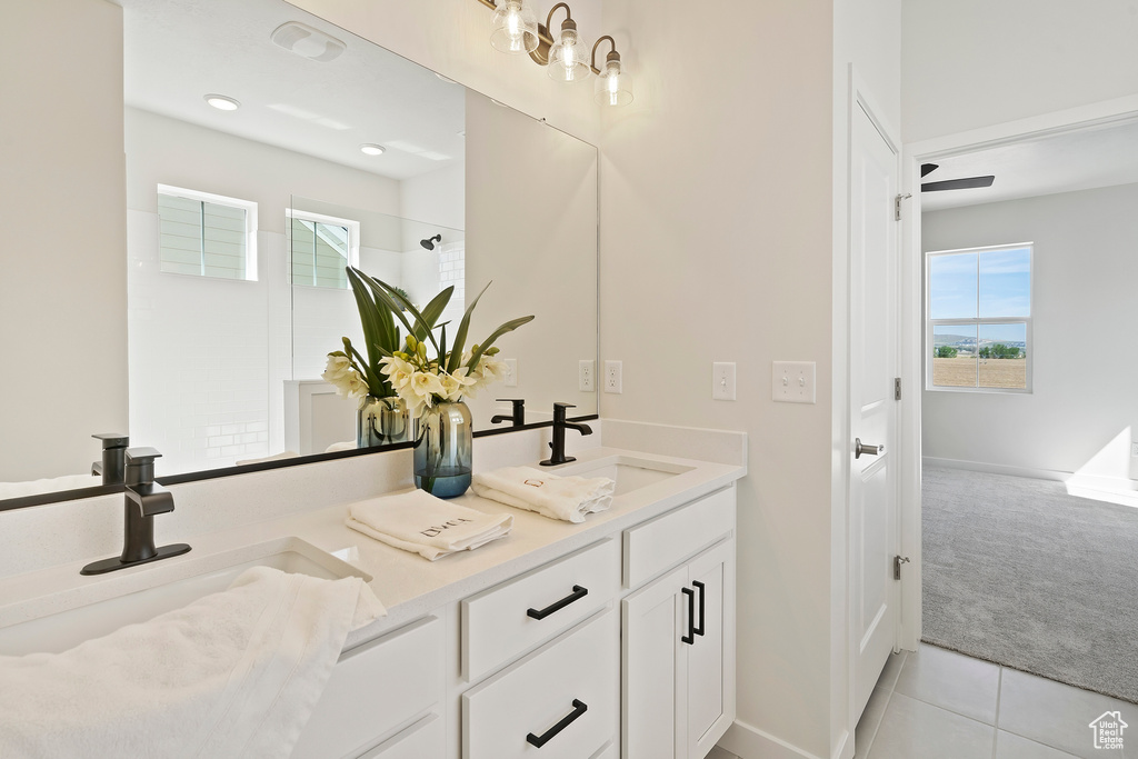Bathroom with double vanity, tile patterned flooring, baseboards, and a shower