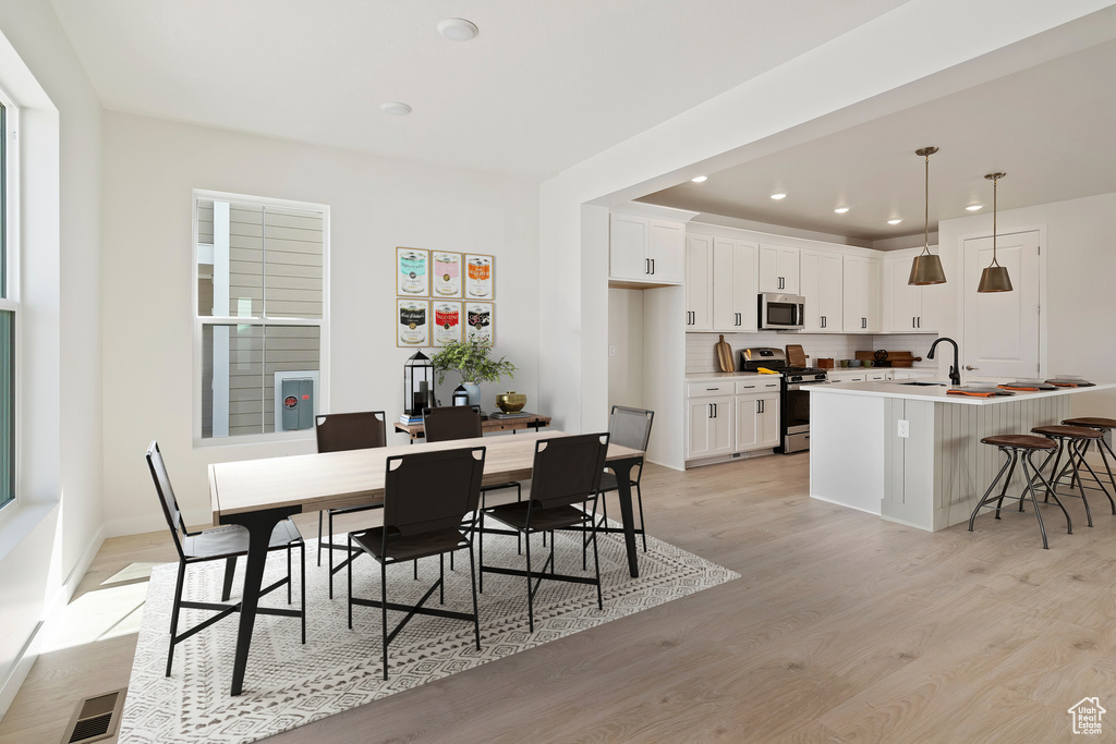 Dining area with light wood-type flooring, recessed lighting, and baseboards