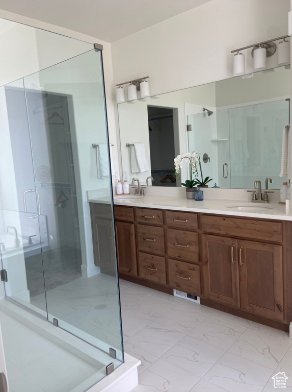 Bathroom featuring a shower with door and vanity