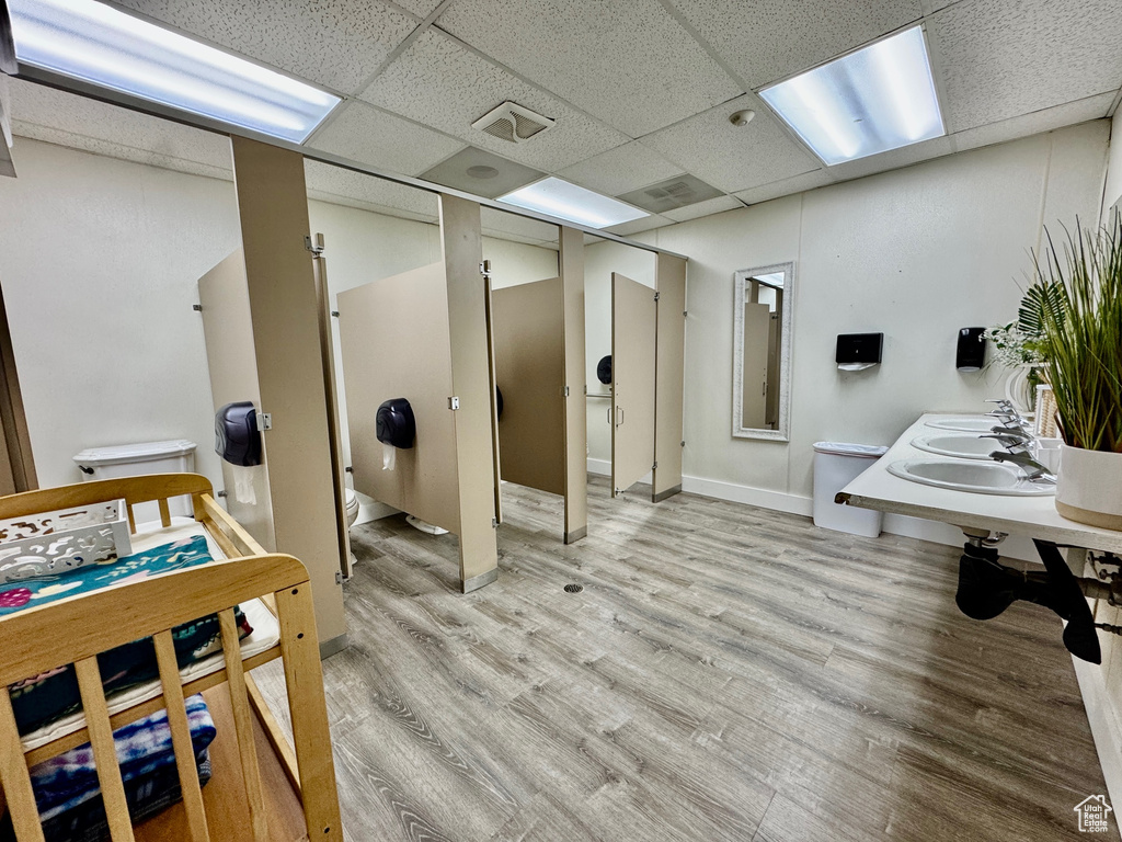 Bathroom with toilet, wood finished floors, and a drop ceiling