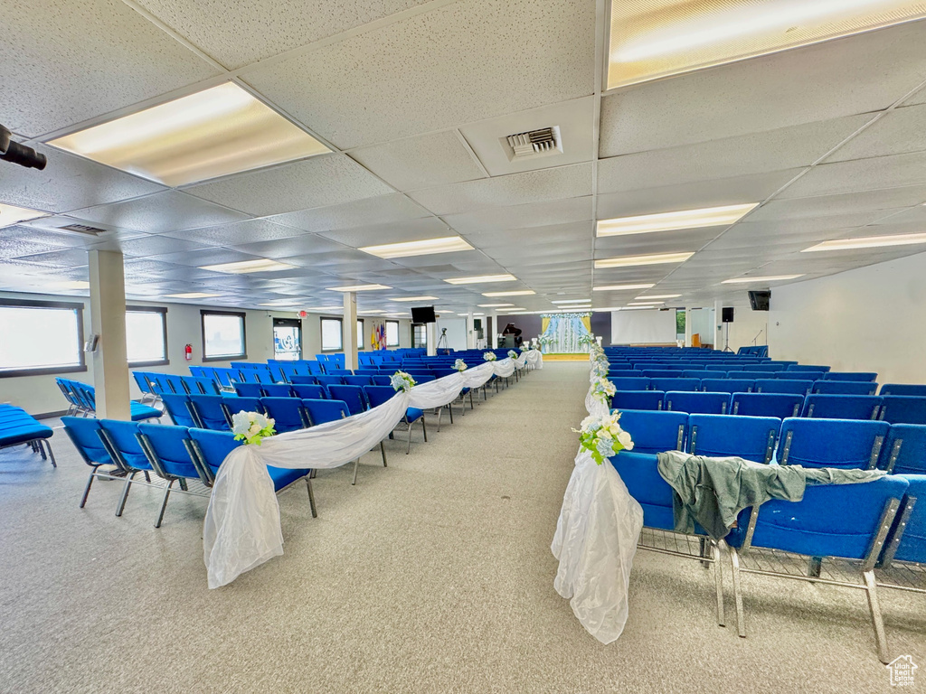 Miscellaneous room with a paneled ceiling and carpet flooring
