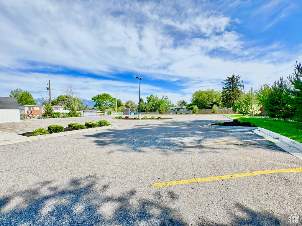 View of asphalt street featuring street lighting and curbs