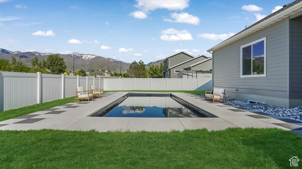 View of pool with a mountain view and a patio area