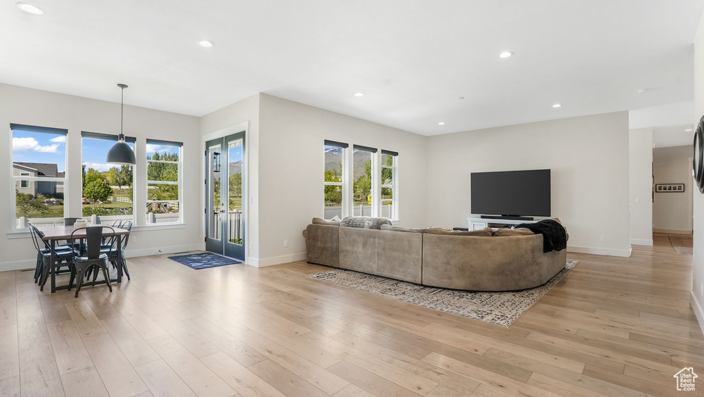 Living room featuring baseboards, light wood-style floors, recessed lighting, and healthy amount of natural light