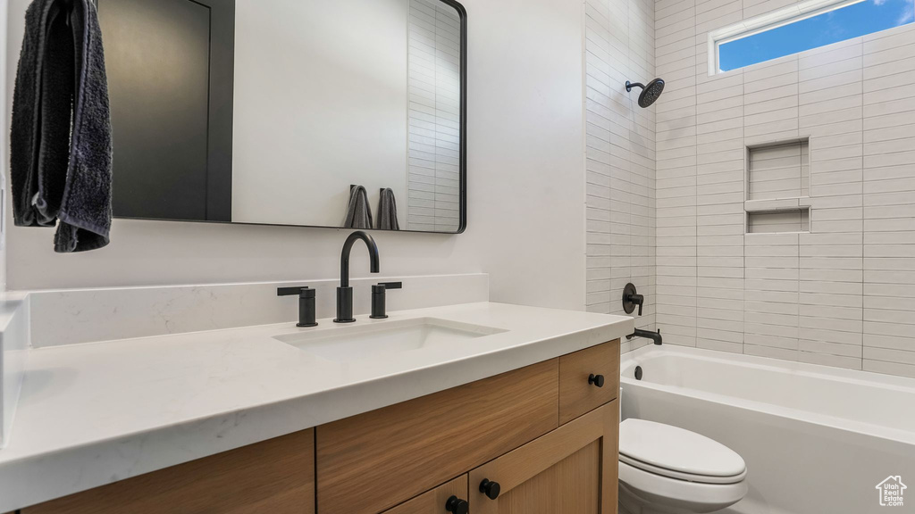 Bathroom with toilet, vanity, and shower / bath combination