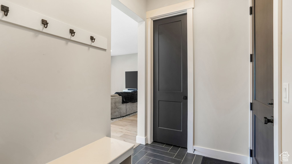 Mudroom featuring dark tile patterned floors and baseboards