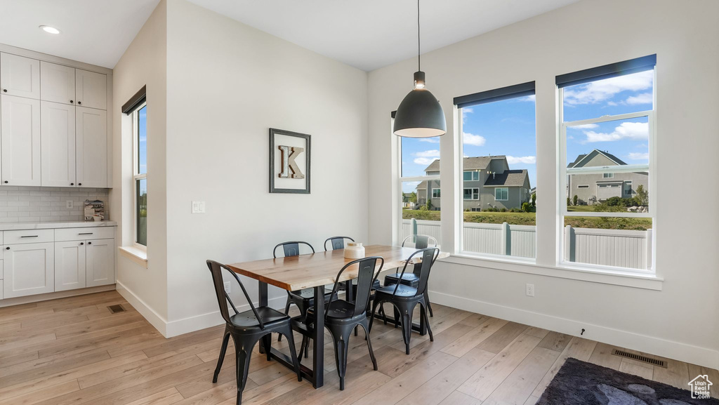 Dining space featuring healthy amount of natural light, light wood-style floors, baseboards, and recessed lighting