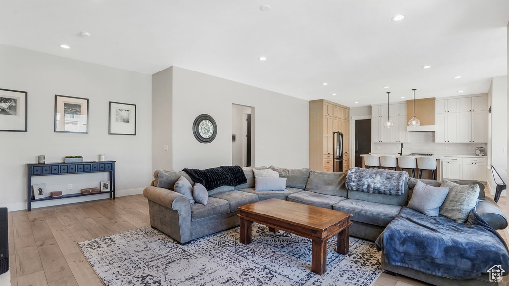 Living area with light wood-style flooring, recessed lighting, and baseboards
