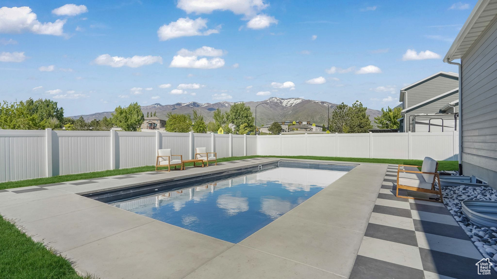 View of pool with a mountain view, a fenced backyard, and a patio