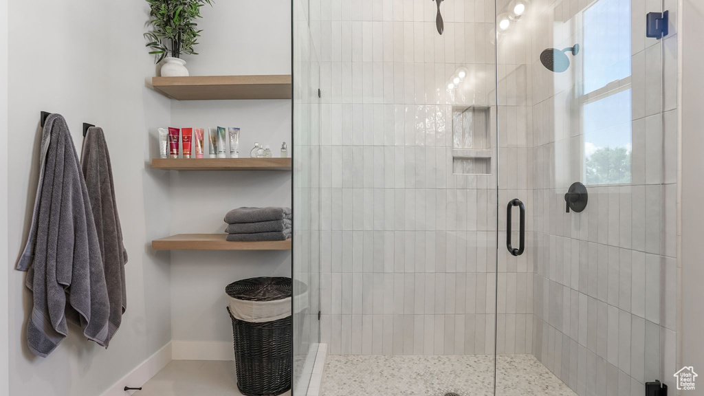 Full bath featuring a stall shower and baseboards