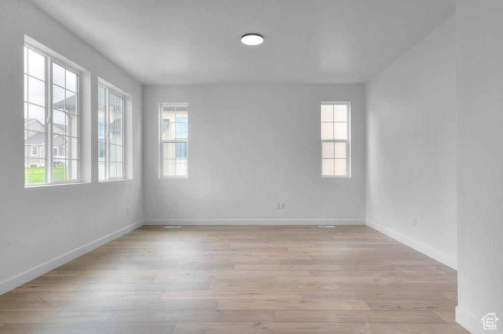 Spare room with baseboards and light wood-style floors